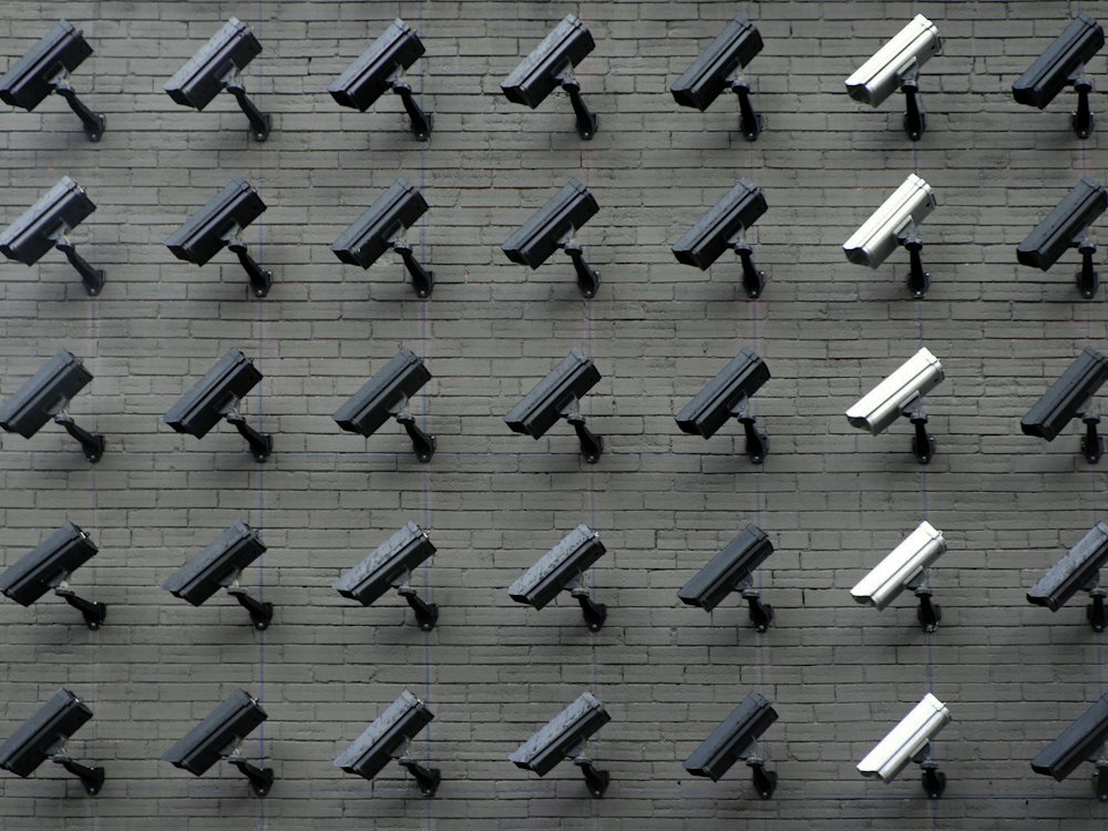 Rows of security cameras mounted on a wall
